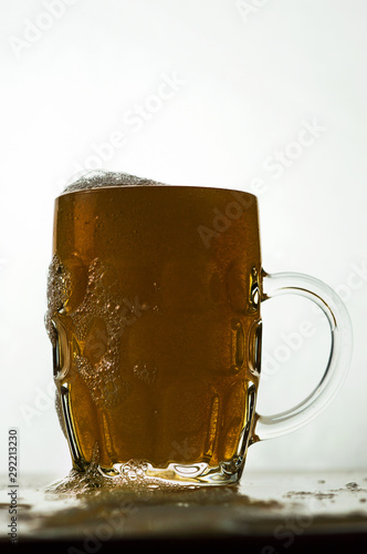 foamy beer in a transparent glass on a white background photo