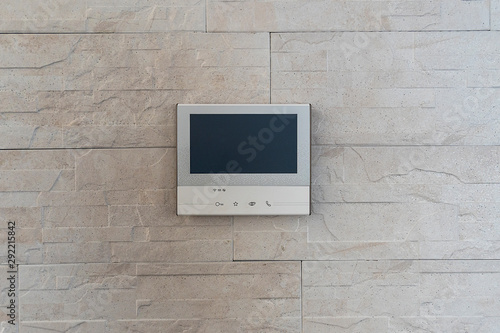 The smart home system is installed in the apartment on the wall. The intercom with video surveillance of the apartment is a modern system with a large.