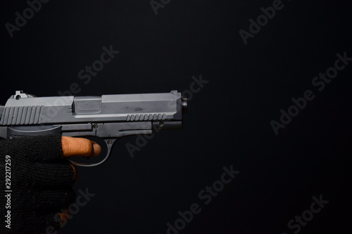 asian man holds a gun. Gun in his hand. Killed shooting his target isolated on black background.