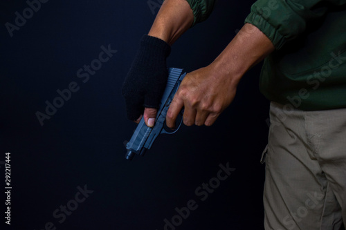 asian man holds a gun. Gun in his hand. Killed shooting his target isolated on black background.