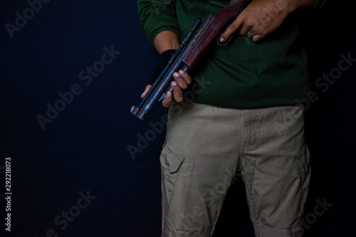 asian man holds a gun. Gun in his hand isolated on black background.