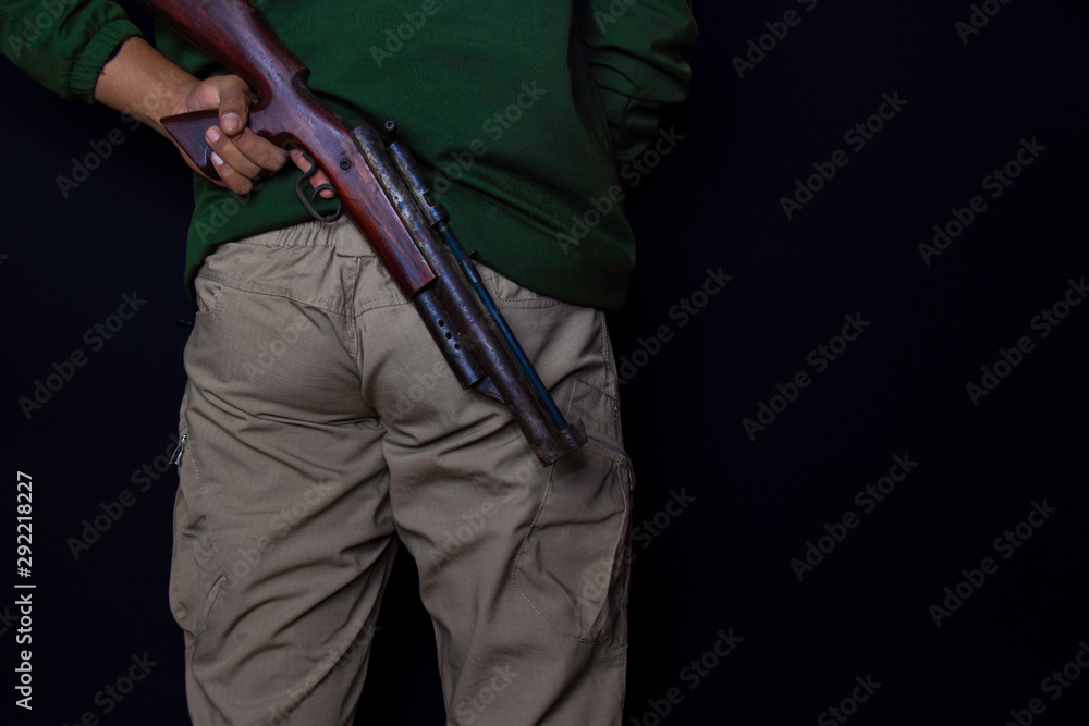 asian man holds a gun. Gun in his hand isolated on black background. asian man holds a gun. Gun in his hand isolated on black background.