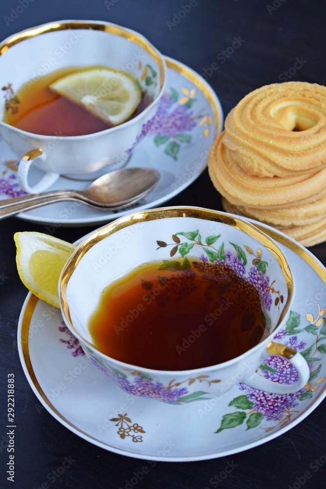 Fresh fragrant tea with lemon in a beautiful Cup on a black background. Fresh fragrant tea with lemon in a beautiful Cup on a black background.