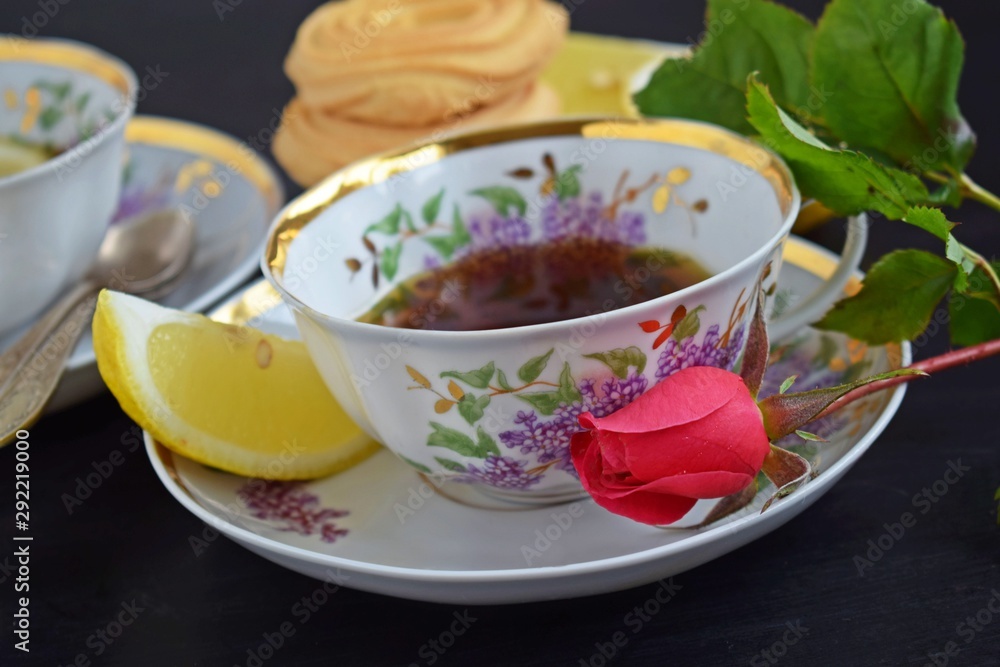 Fresh fragrant tea with lemon in a beautiful Cup on a black background. Fresh fragrant tea with lemon in a beautiful Cup on a black background.
