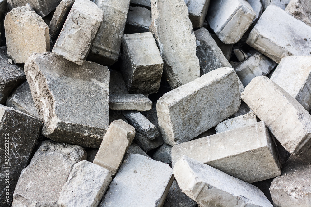 Pile of disassemble gray concrete bricks. close-up of scattered stone pavement bricks texture. Pile of disassemble gray concrete bricks. close-up of scattered stone pavement bricks texture.