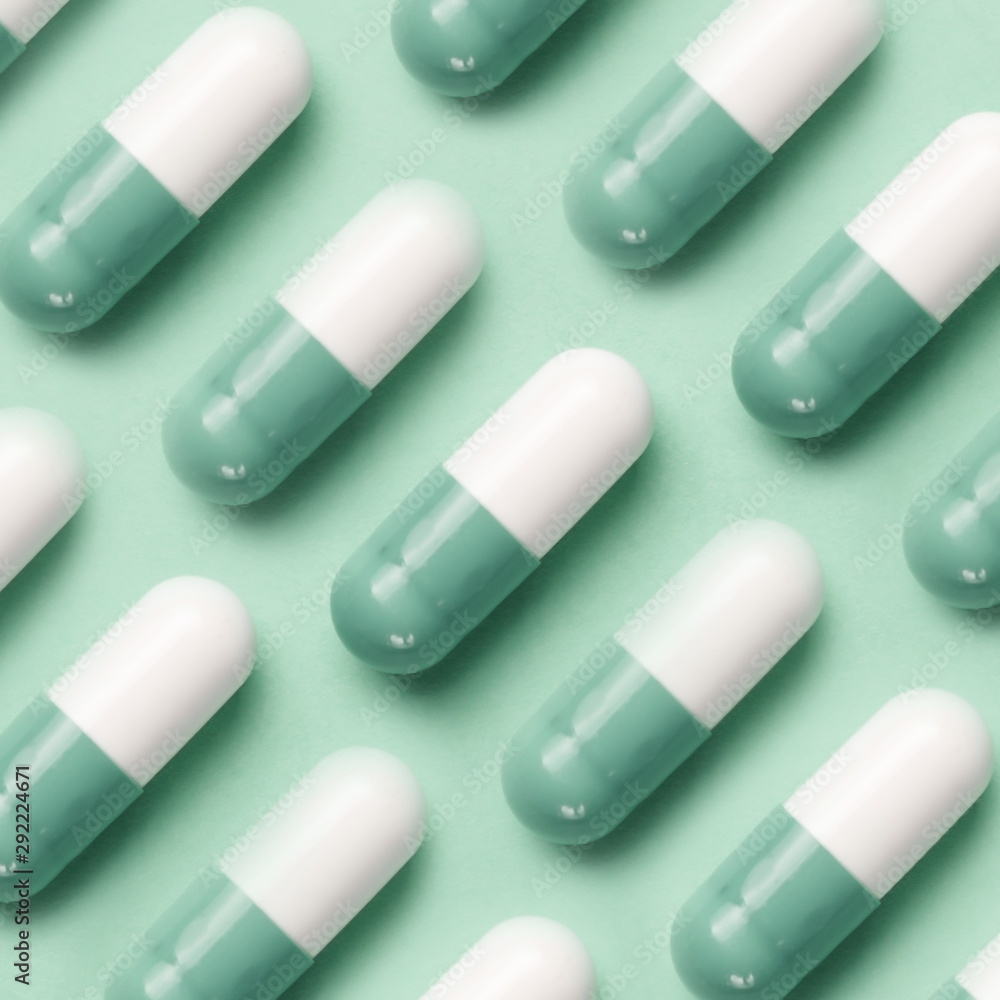Medical pattern made with pills on mint background. Pharmaceutical medicine pills, tablets and capsules on mint background. Flat lay. Medicine concepts. Minimalistic abstract concept. Neo mint color Medical pattern made with pills on mint background. Pharmaceutical medicine pills, tablets and capsules on mint background. Flat lay. Medicine concepts. Minimalistic abstract concept. Neo mint color