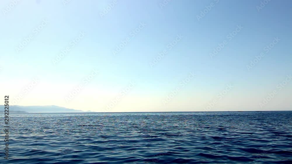 View from water moving sideways across ocean horizon blue sky Sardinia Sardegna Italy View from water moving sideways across ocean horizon blue sky Sardinia Sardegna Italy