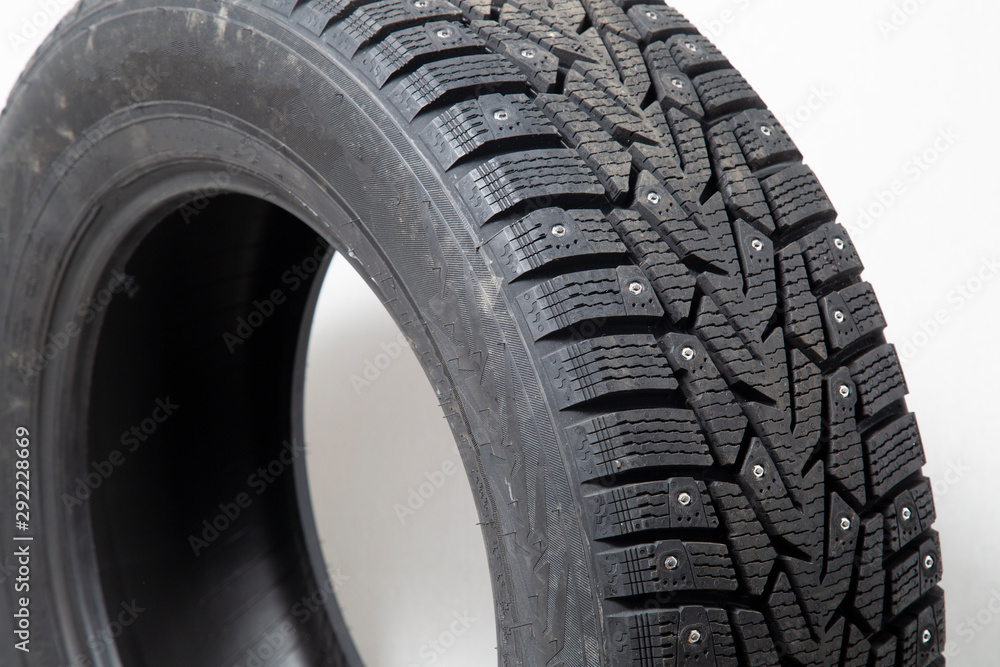 Winter car tires with spikes. Car tires on white background. Shop tires and wheels. Winter car tires with spikes. Car tires on white background. Shop tires and wheels.
