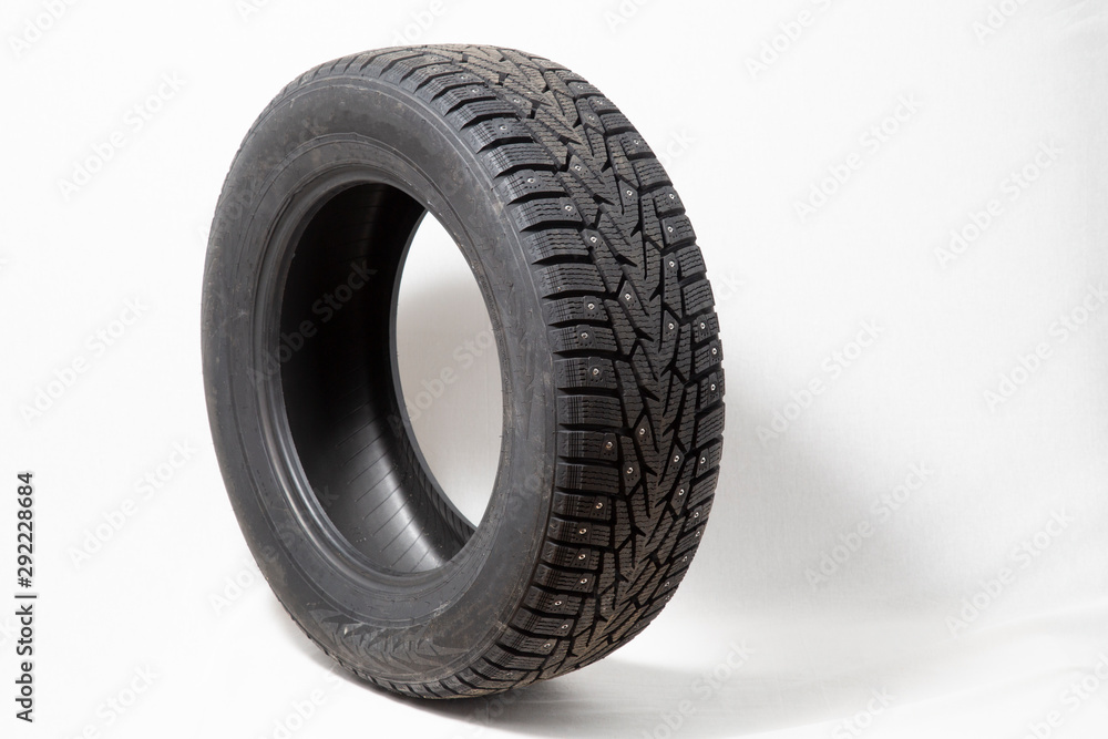 Winter car tires with spikes. Car tires on white background. Shop tires and wheels.