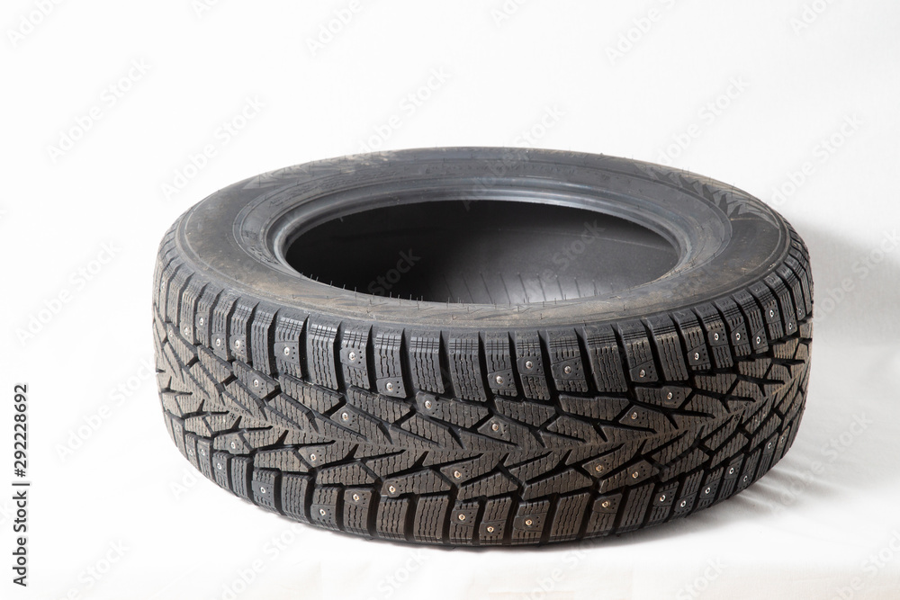 Winter car tires with spikes. Car tires on white background. Shop tires and wheels. Winter car tires with spikes. Car tires on white background. Shop tires and wheels.