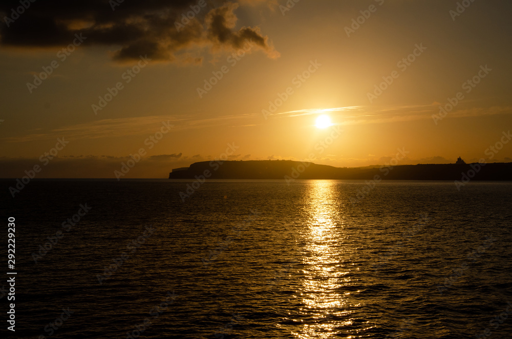 Sunset and red orange sky in Gozo, Malta. Golden orange sunset. Mediterranean Sea Sunset and red orange sky in Gozo, Malta. Golden orange sunset. Mediterranean Sea