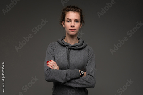 Portrait of young woman in grey hoodie against gloomy background isolated photo