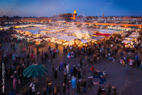 Crowd in Jemaa el Fna square at sunset, Marrakesh, Morocco. People blur to imply their movements. photo