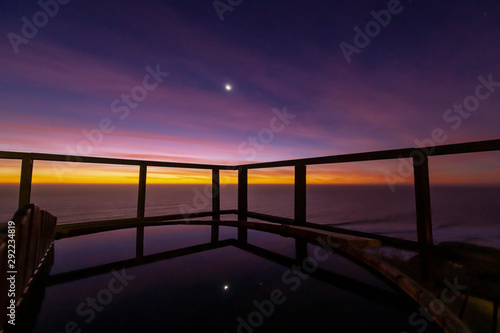 An amazing an idyllic view a wooden hot tub waiting us for some relaxation time during sunset and twilight before an awe night sky with a small crescent moon. A leisure activity at Chilean coastline © abriendomundo