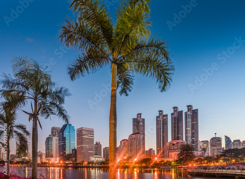 Lake in City Park under Skyscrapers at Twilight. Benjakiti Park in Bangkok, Thailand photo