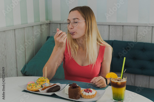 Girl in a cafe eats sweet and fresh desserts.