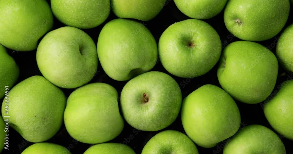 Green apples on black background, slow zoom in and rotation Green apples on black background, slow zoom in and rotation