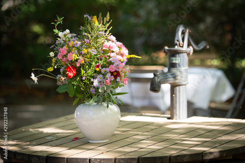 Wunderschöner sommerlicher Blumenstrauß steht auf einem abgedeckten Brunnen