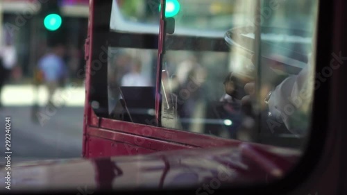 Reflections in window of classic red London routemaster bus, downtown London, UK. Concept of historic English culture, iconic British capital commute. photo