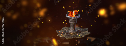 Hot coals in a shisha's bowl with spectacular red sparks, inox clamp. Dark textured background