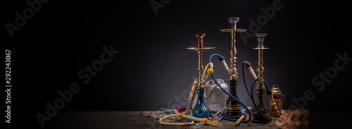 Rustic handmade hookah and arabic tea for relaxation in a dark moody room, rustic decoration, smoke and shisha components photo