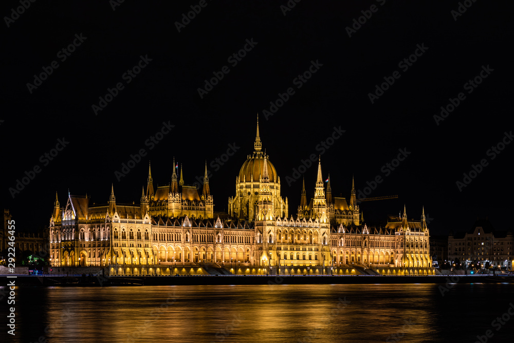 Stunning view of the Hungarian Parliament Building at the bank of River Danube at night in Budapest, Hungary
