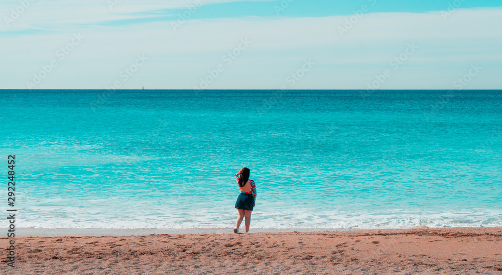 Frau steht am Strand