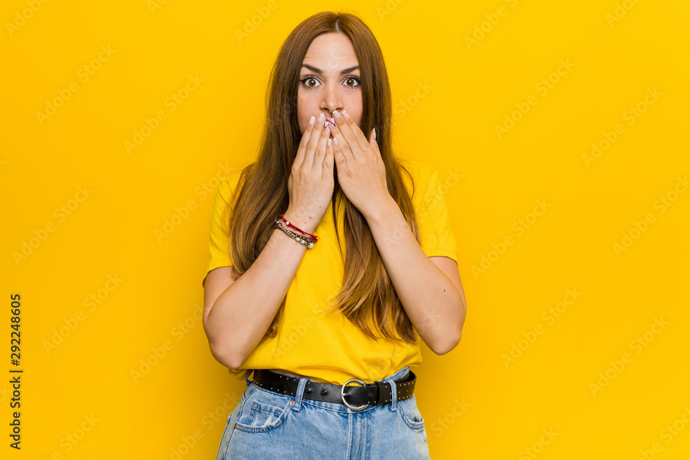 Young ginger redhead woman shocked covering mouth with hands. Young ginger redhead woman shocked covering mouth with hands.
