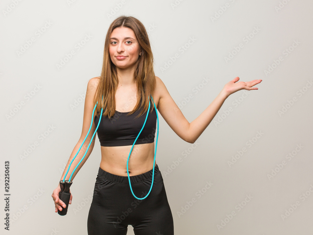 Young fitness russian woman confused and doubtful. Holding a jump rope. Young fitness russian woman confused and doubtful. Holding a jump rope.
