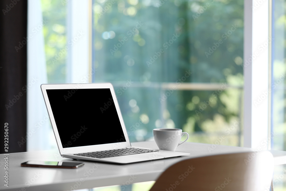 Comfortable workplace with modern laptop on desk in home office, space for text Comfortable workplace with modern laptop on desk in home office, space for text