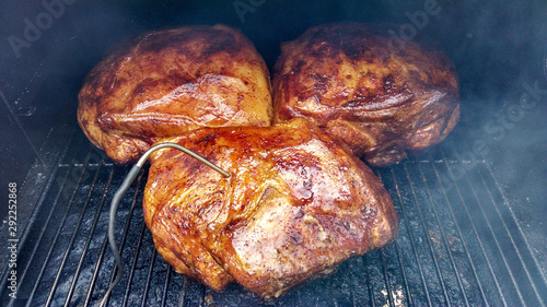 Smoked Pork shoulder smoking on the grill with a temperature probe
