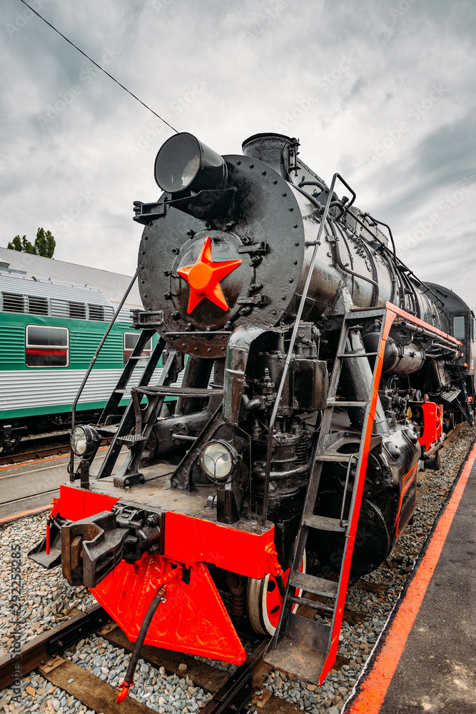 Obraz premium Old black steam locomotive on railway station
