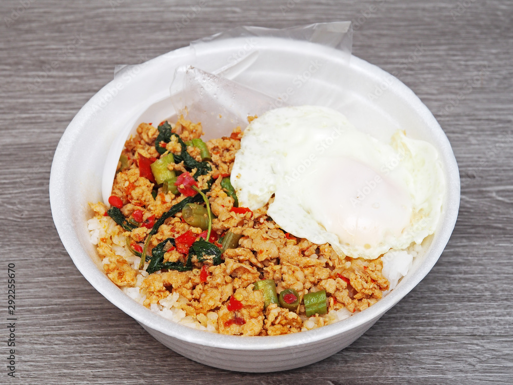 Stir fried minced pork with fried egg on rice in takeout food box for lunch. Thailand street food. Stir fried minced pork with fried egg on rice in takeout food box for lunch. Thailand street food.