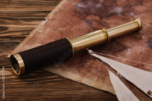 old world map and telescope near sail on wooden surface