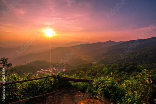 Natural panoramic scenery background, which can see the surrounding atmosphere (trees, green leaves, mountains, fog, soft sunlight, colorful sky) with blurred wind blowing, cool air