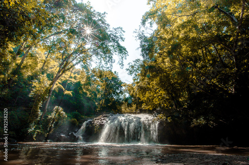 Natural blurred background of waterfalls, fast-flowing currents and water droplets from the wind blowing among the rocks and surrounded by big trees, spontaneous beauty © bangprik