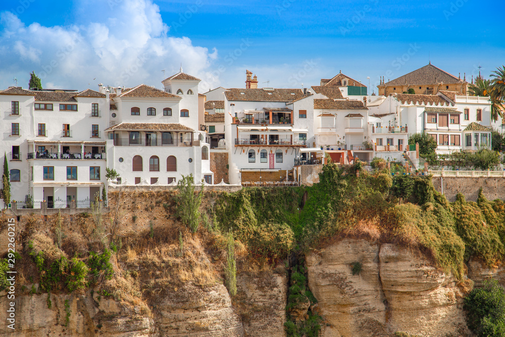 Ronda, Spain-September 12, 2019: Famous Ronda restaurants and colonial houses overlooking the scenic gorge and the Puente Nuevo bridge