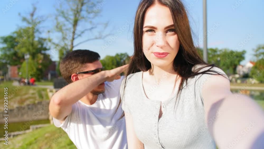 Cheerful young couple take a selfie portrait in the park. Happy together. Close up shot. Cheerful young couple take a selfie portrait in the park. Happy together. Close up shot.