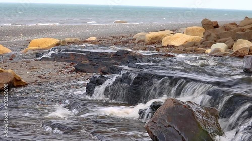 Wallpaper Mural Water flowing from a wide stream flowing over rocks creating a small waterfall on beach in Kenai Peninsula of Alaska Torontodigital.ca