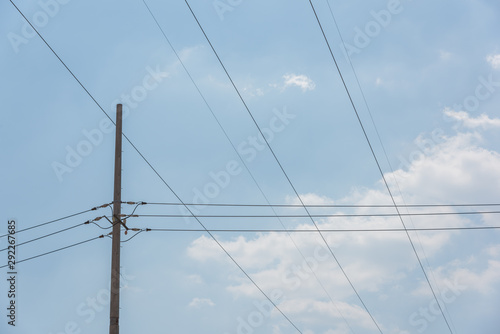 Closeup of a cement pole and neat wires network in blue sky background