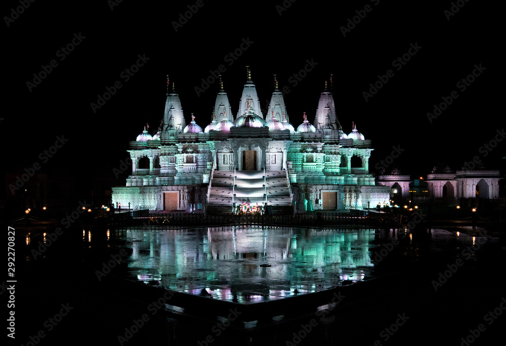 Chino hindu temple all lit up in lights with beautiful reflection in a pool