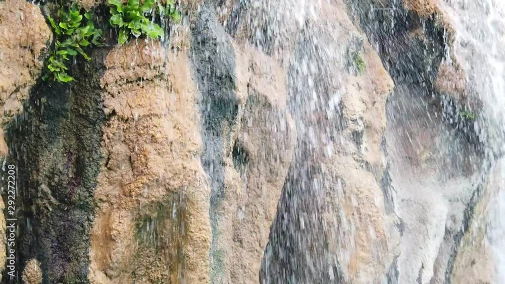 slow motion Waterfall splash on rock into a poolside at hotel spa resort slow motion Waterfall splash on rock into a poolside at hotel spa resort