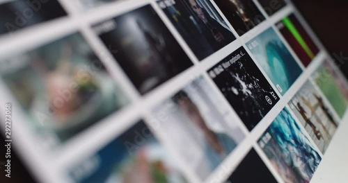 Content manager searching video media on internet web site close up slow motion. Notepad screen macro shot side view with bright preview squares social communication freelance business