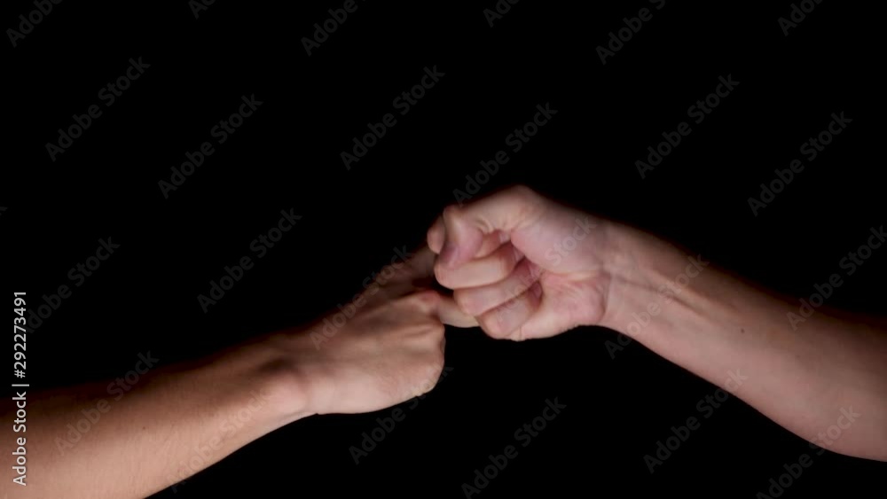 Slow motion shot of two hands playing each other in Rock Paper Scissors. Rock beats Scissors. The hands are illuminated in front of a black background. Slow motion shot of two hands playing each other in Rock Paper Scissors. Rock beats Scissors. The hands are illuminated in front of a black background.