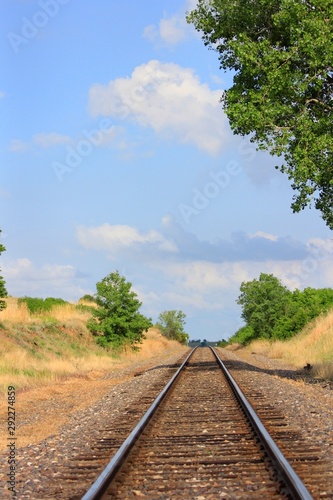 Railway on the Kansas prairie with tree's and blue sky. photo