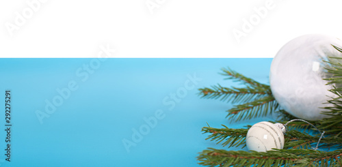 Christmas balls on the tree. Decorations of white balls. Blue and white background. Space for text