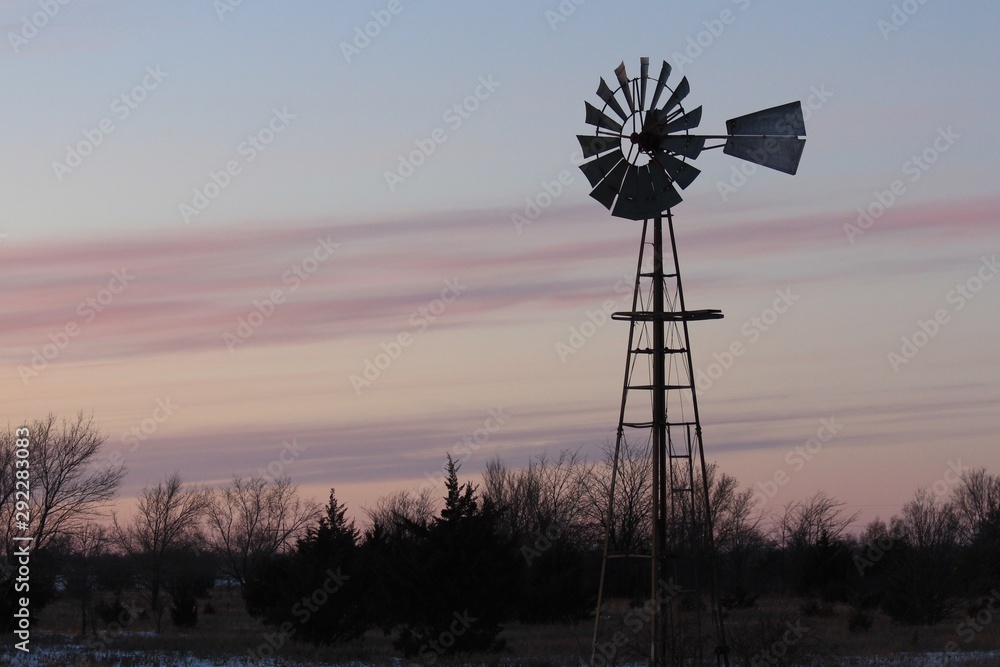 windmill at sunset in the winter in Kansas. windmill at sunset in the winter in Kansas.