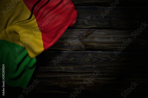 pretty dark picture of Mali flag with big folds on old wood with empty place for text - any holiday flag 3d illustration..