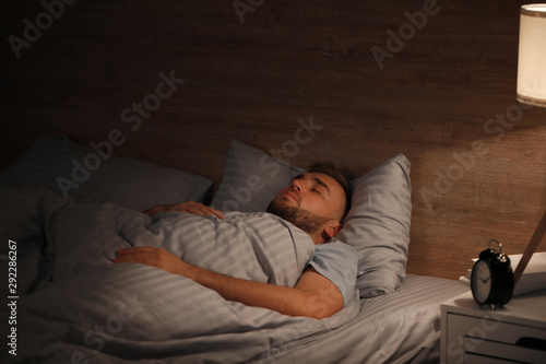 Young man sleeping in bed at night