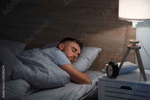 Young man sleeping in bed a...